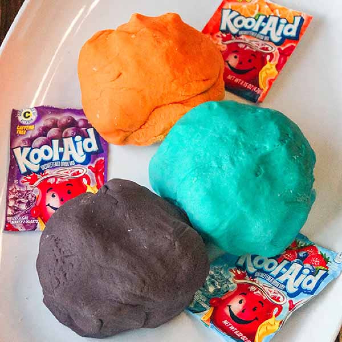 Make this easy Kool Aid Playdough for a fun activity for your kids. Homemade playdough with kool aid is simple to make and the colors are so vibrant. Kool Aid playdough in different color balls.
