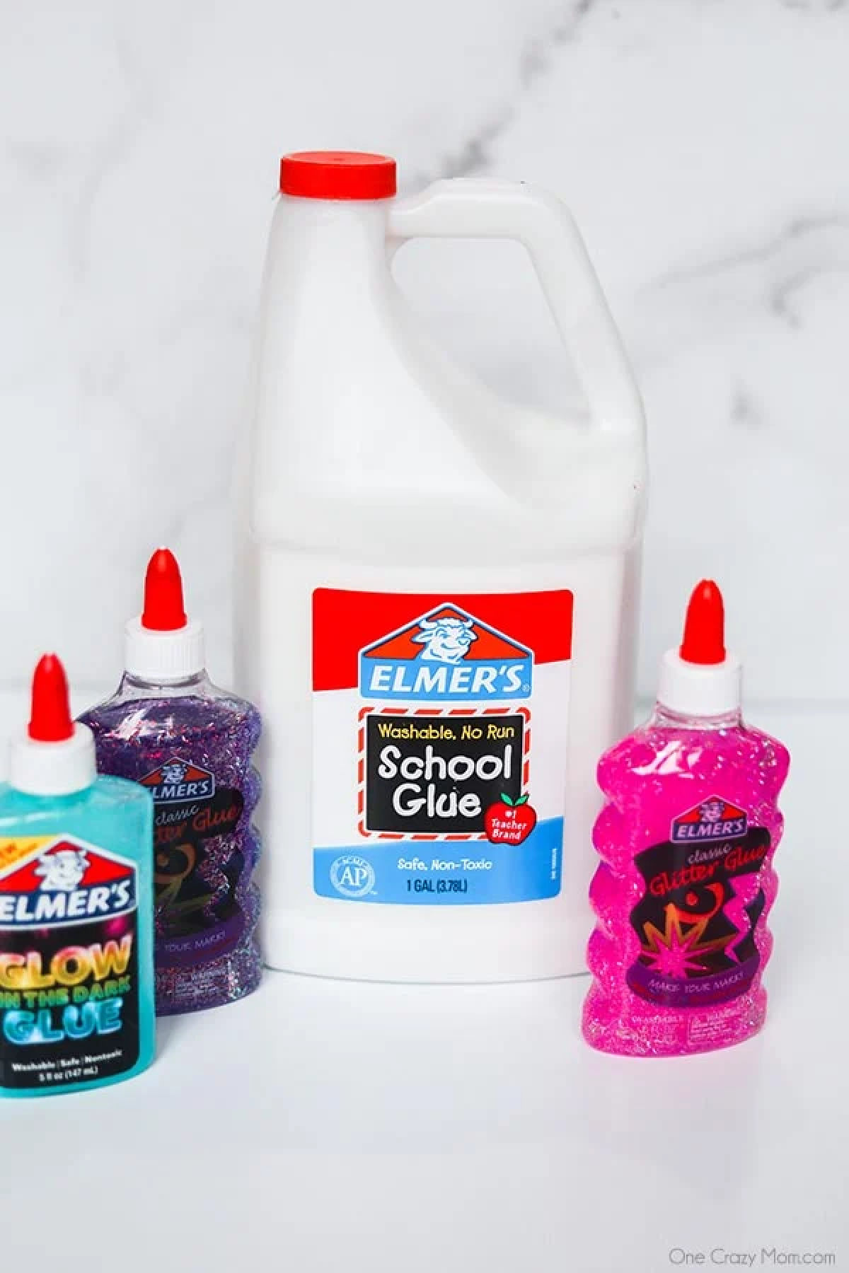 Find out the best slime supplies needed to start fun slime experiments including the best place to get slime supplies and cheap slime supplies! You’ll love this slime supplies list including items that can be found at the dollar store. If your kids love slime, you’ll want to review this supplies list today! #onecrazymom #slimesupplies #slime Slime supplies - gallon of white glue, pink glitter glue, purple glue, glow in the dark glue.