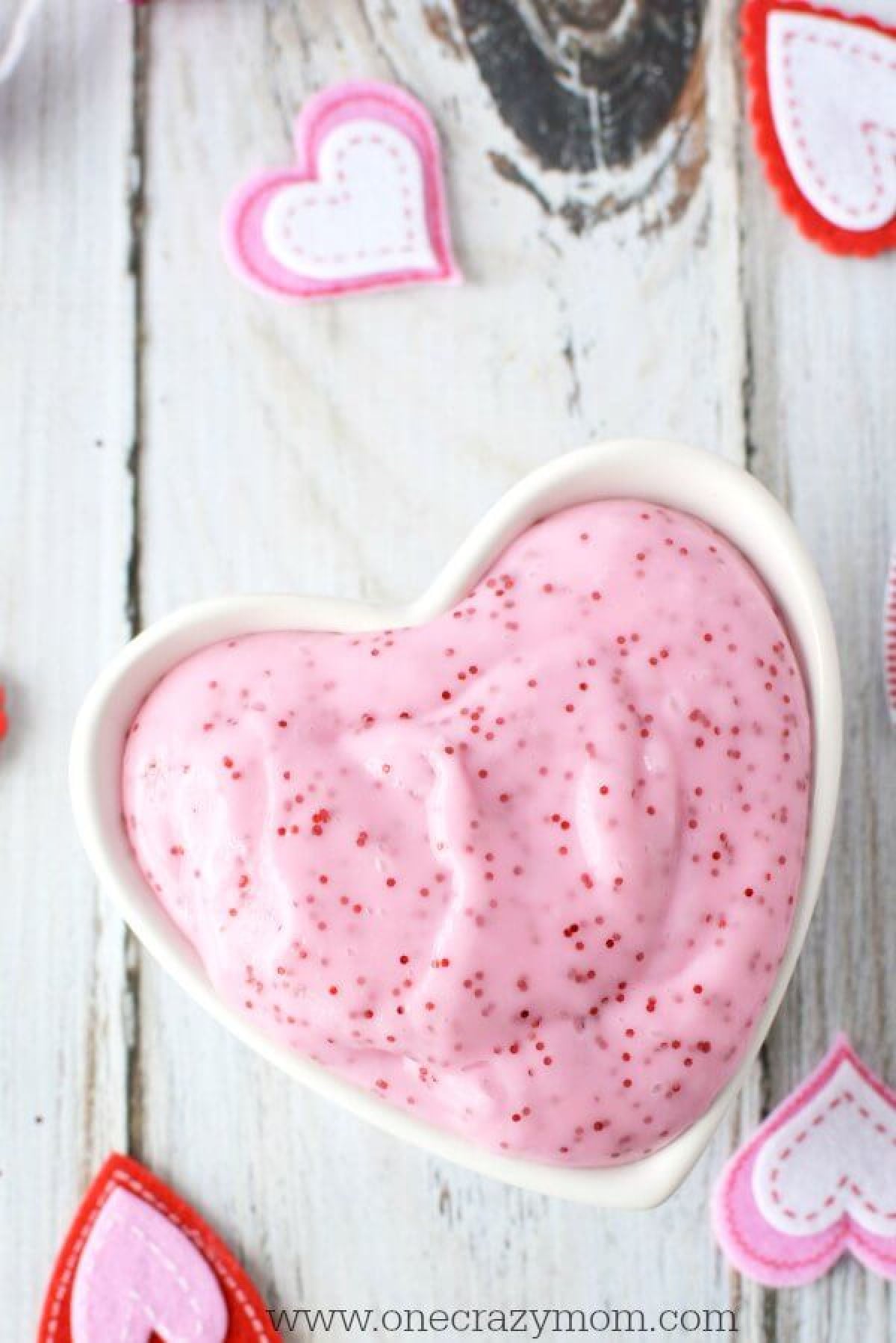 Make this easy Valentines day slime recipe with your kids. They will love Valentine's Day Homemade Slime. Slime is a fun alternative to Valentine's candy. Valentine Slime in bowl with glitter.