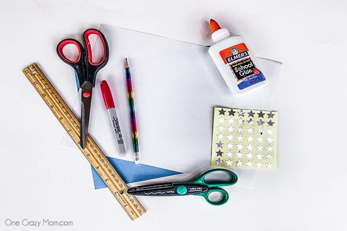 Supplies for pop up card - paper, ruler, scissors, glue, markers, stickers. 