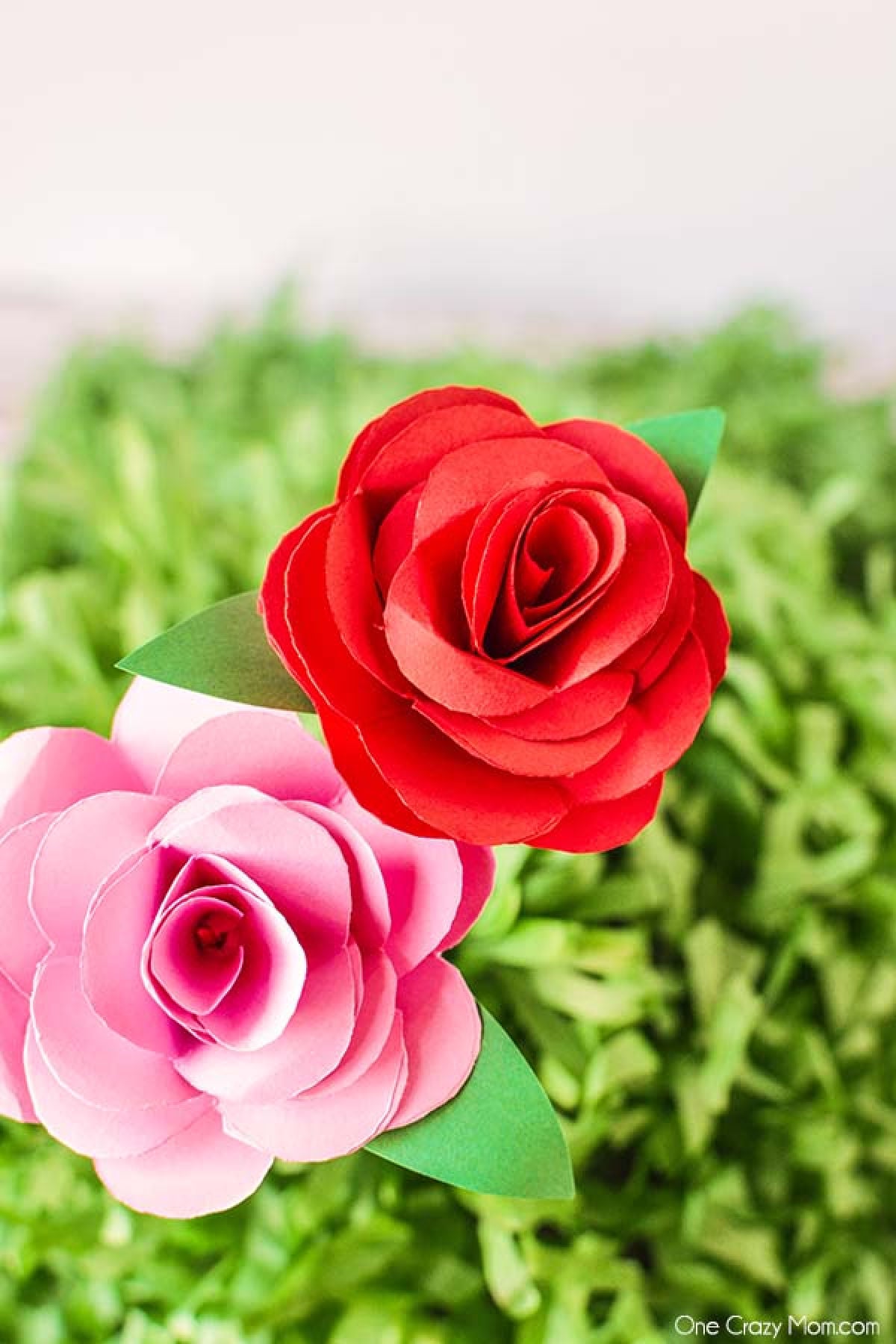 Paper flowers are so fun and perfect for baby showers, decor and much more. Learn how to make paper flowers in just a few easy steps. These are so simple. Paper Flowers with leaves on a wooden skewer.