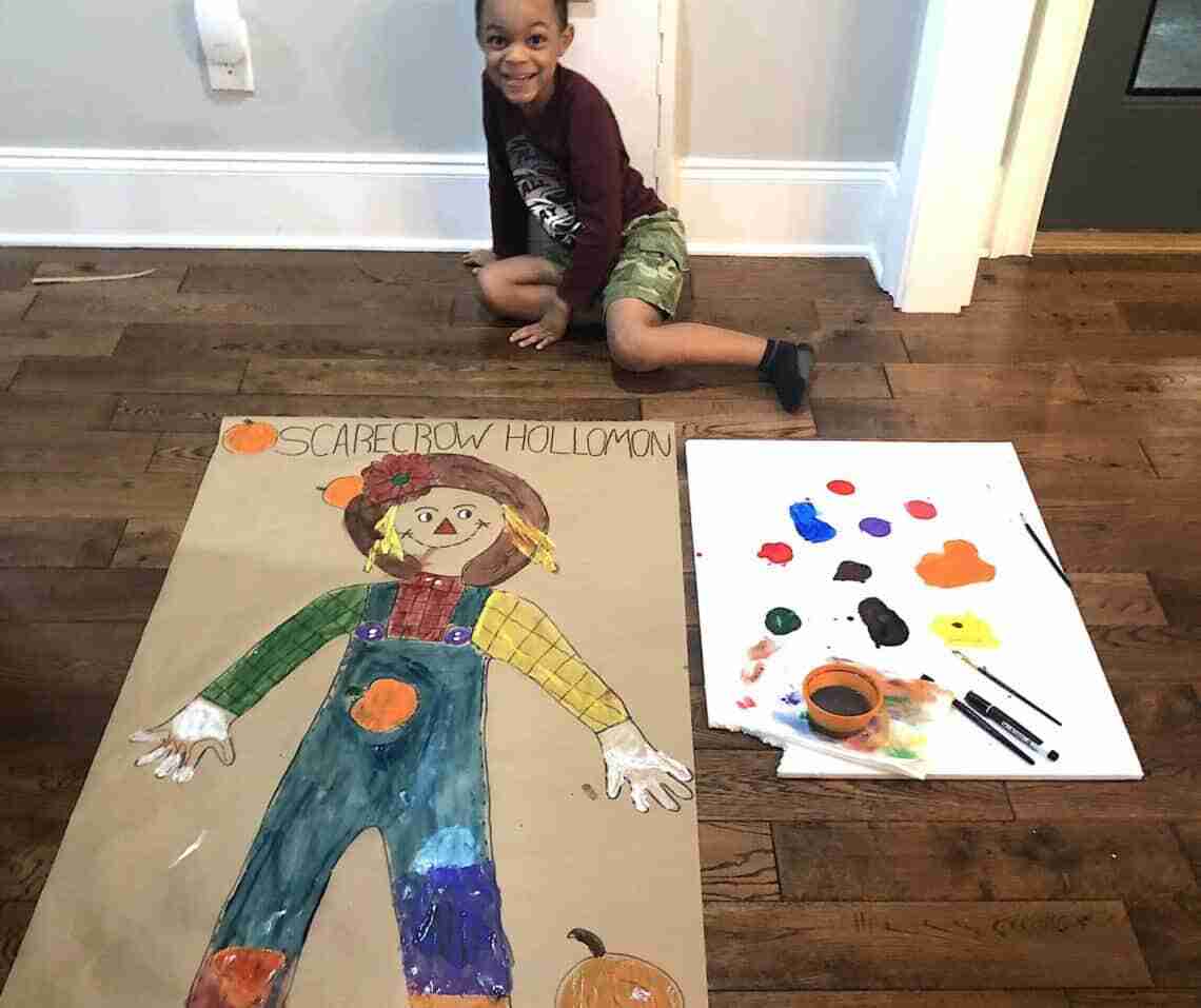 Lifesize scarecrow painting beside a child.
