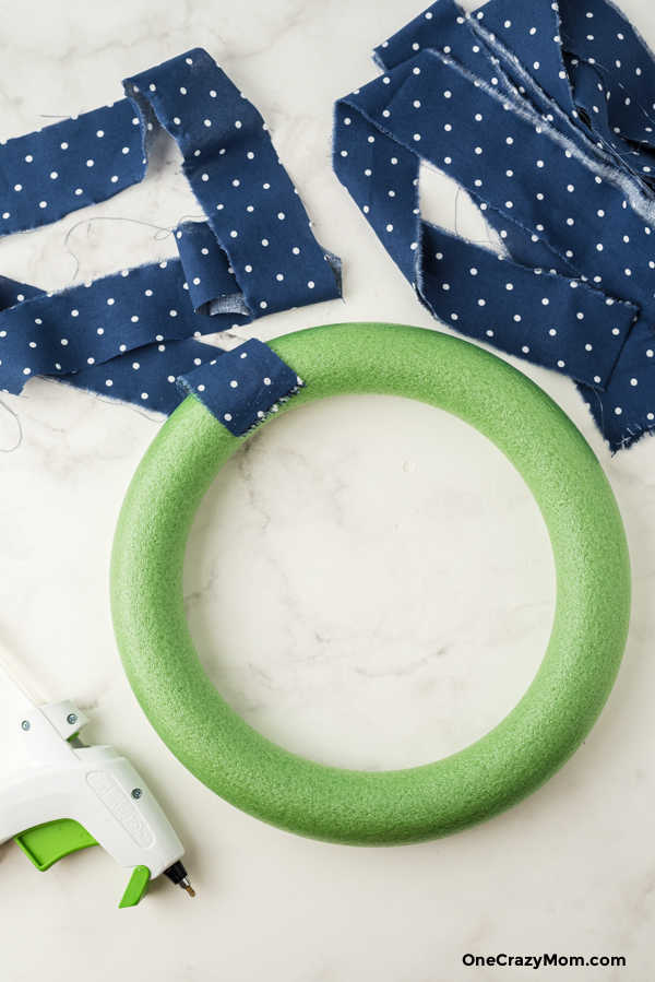 Wrapping strips of fabric on wreath.
