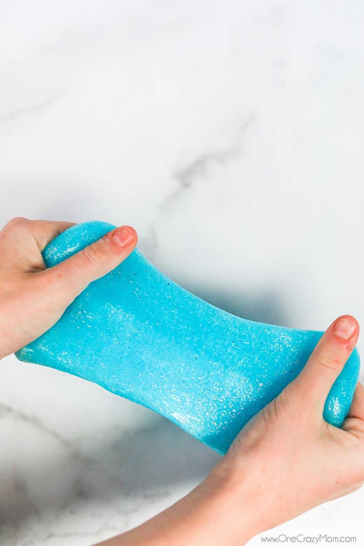 Slime being stretched and pulled in hands.