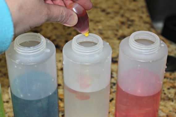 Looking for winter activities for kids? Learn How to make Snow Paint - Snow painting is fun. This is our favorite winter activities for toddlers. Adding food coloring to each bottle.