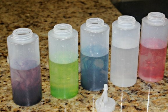 Looking for winter activities for kids? Learn How to make Snow Paint - Snow painting is fun. This is our favorite winter activities for toddlers. Bottles of snow paint in various colors.