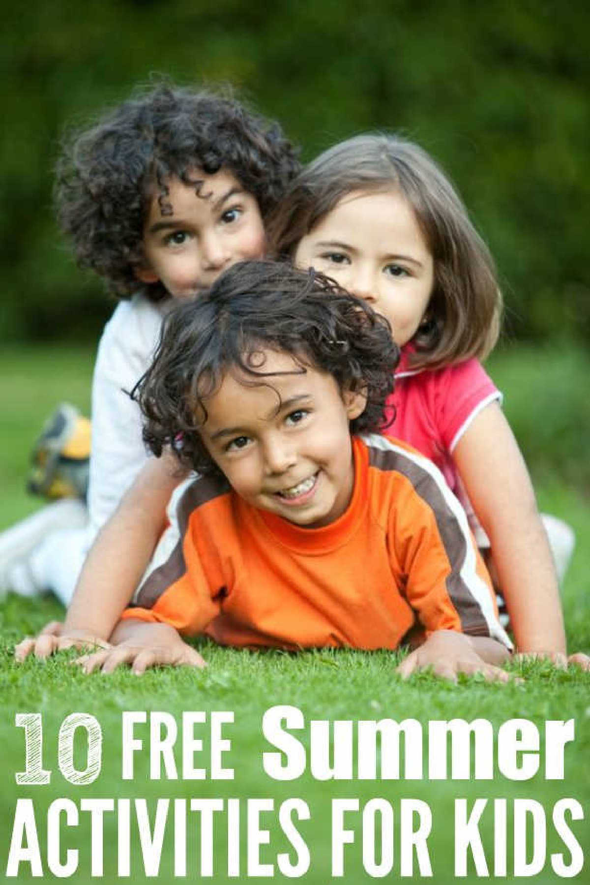 Kids in a pile in the grass.