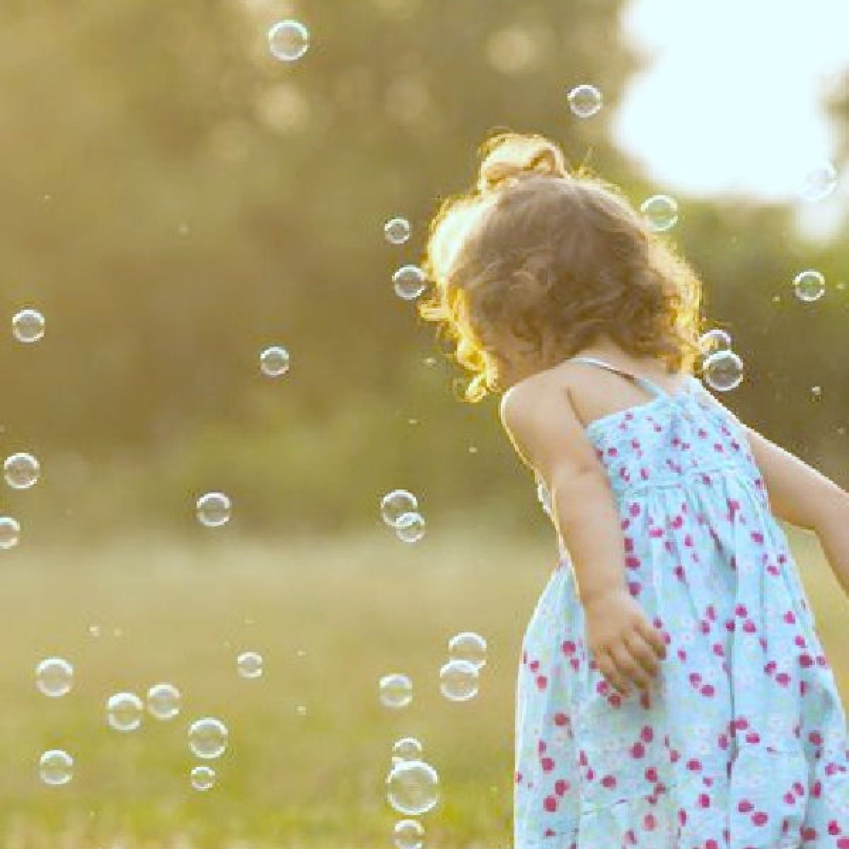 Little girl blowing bubbles.