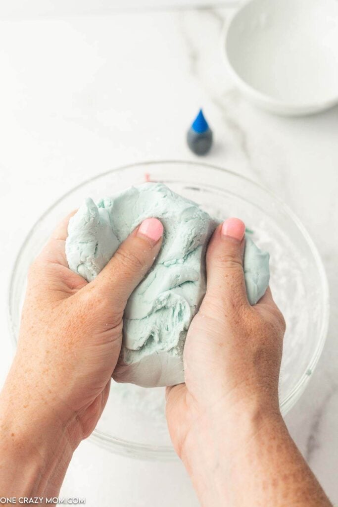 Mixture being combined with hands. 