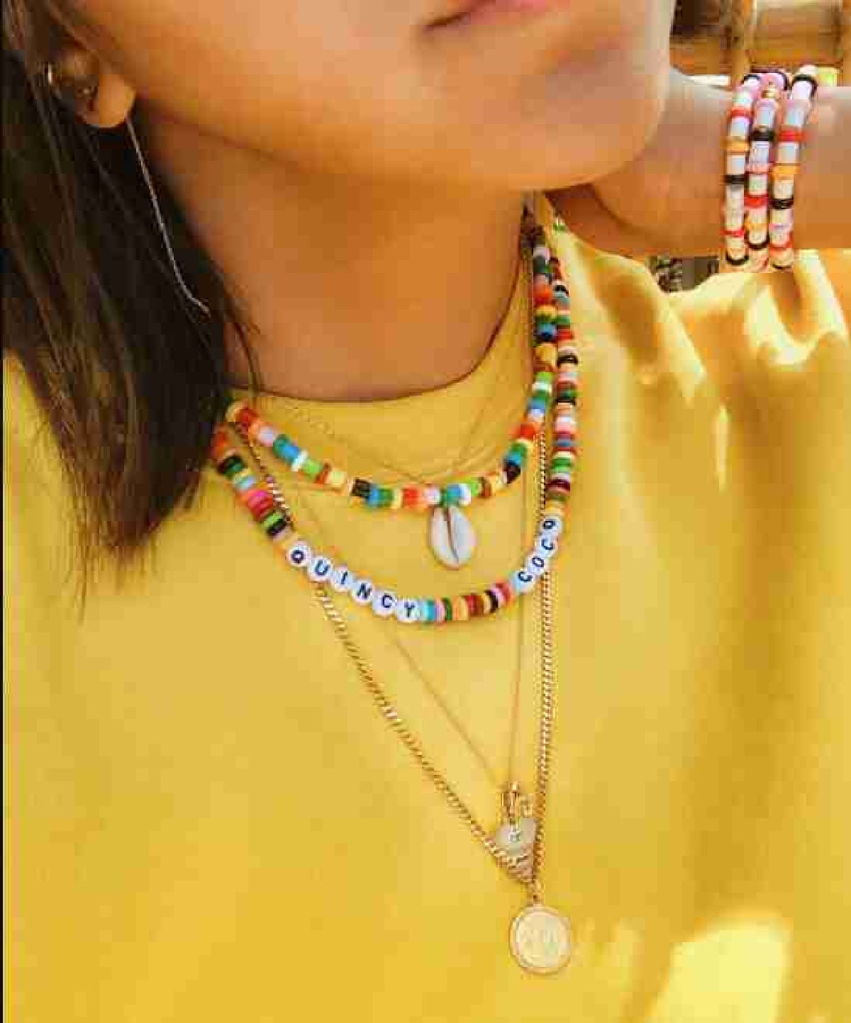 Perler bead necklaces and bracelets on a woman.