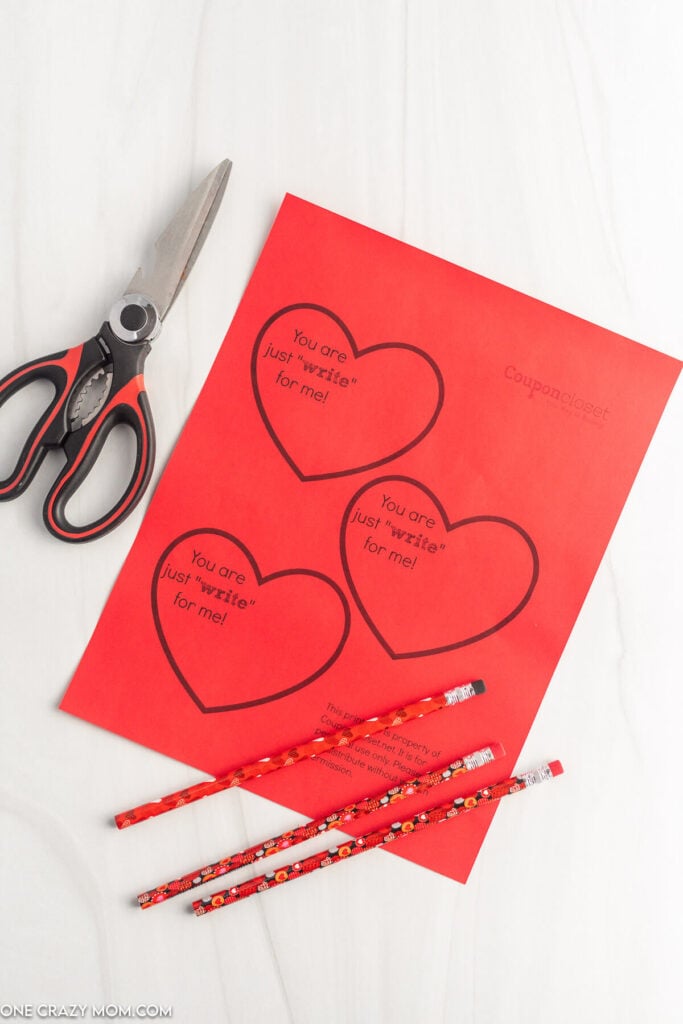 Paper hearts ready to cut out with pencils.