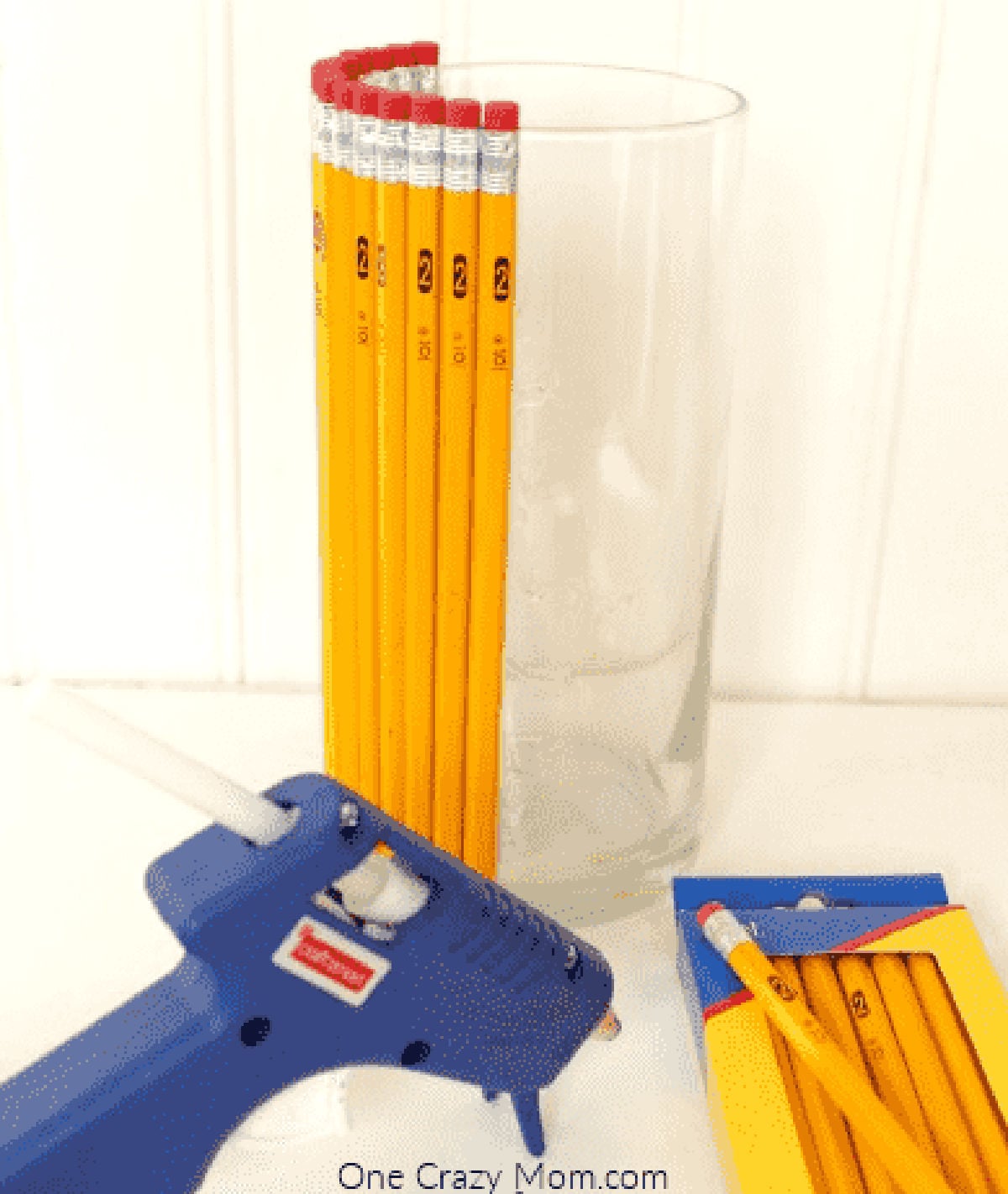 Pencils being glued on the vase. 