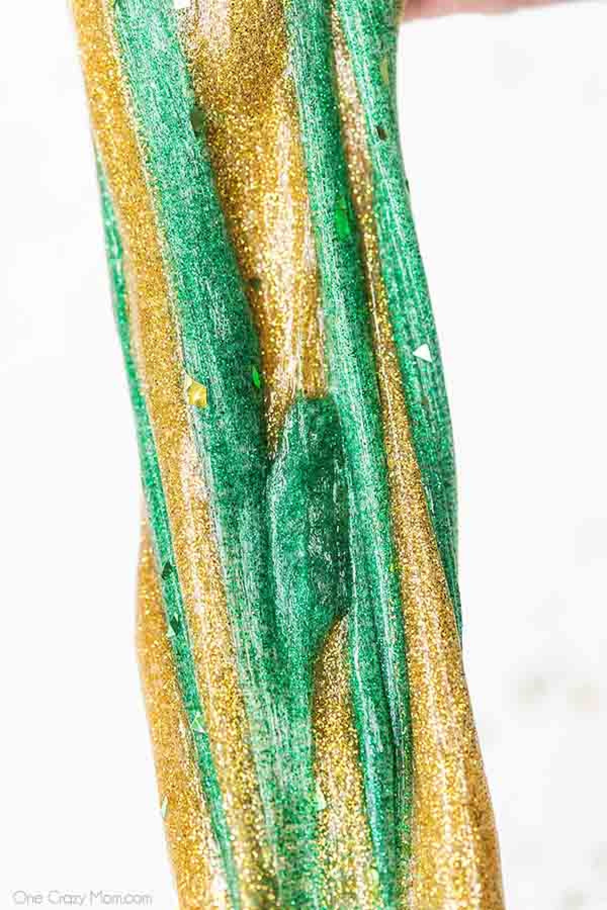 Everyone loves to make slime and your kids will go crazy over this St Patrick's Day Slime. It is so glittery and fun to make and play with. St Patrick's Day Slime stretched out.