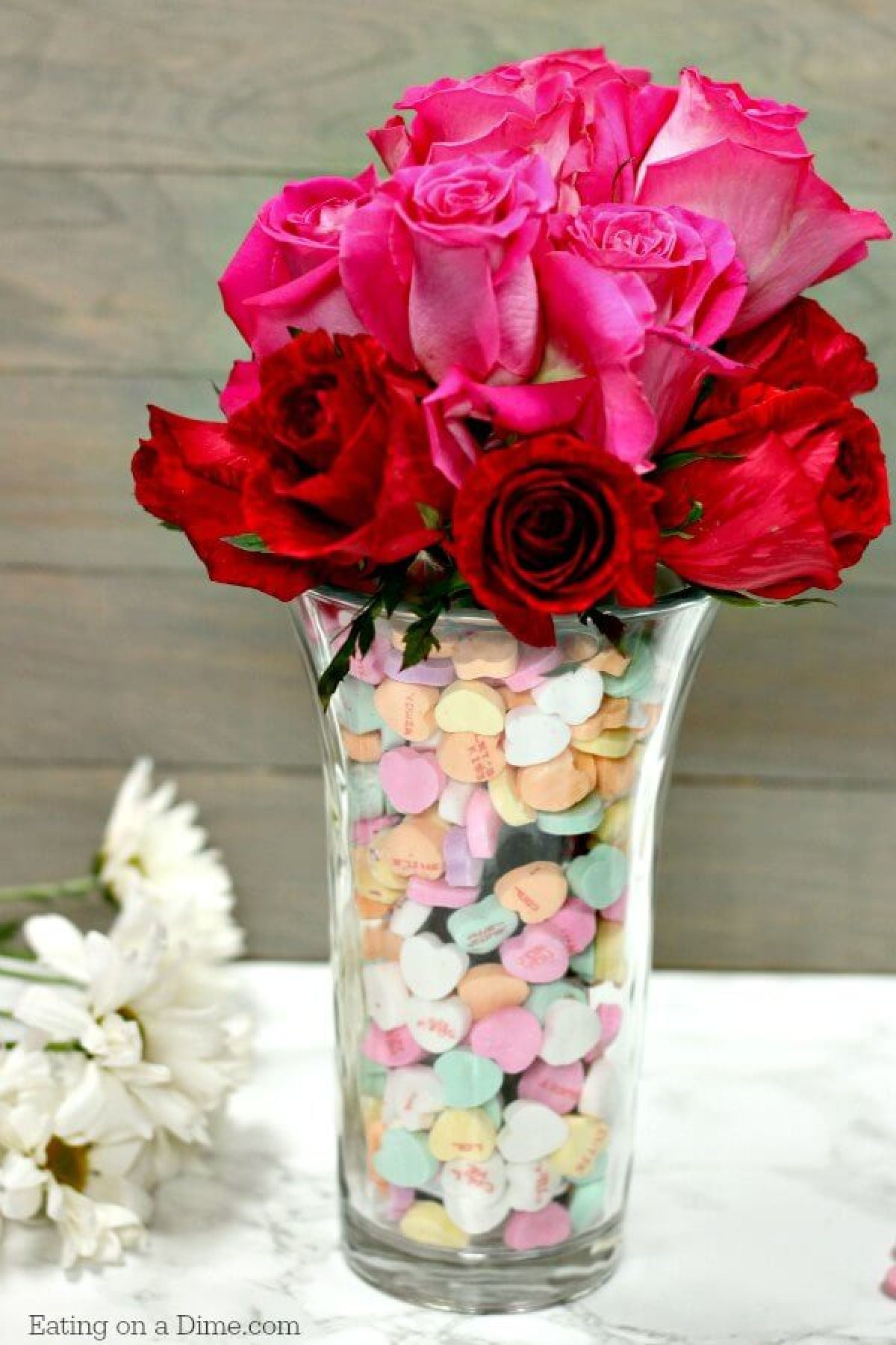 Make this super cute Valentine's Day Centerpiece. This easy DIY Valentine's Day Decor can be created for any holiday! Take those heart candy and decorate with them! Valentines day centerpiece with flowers.