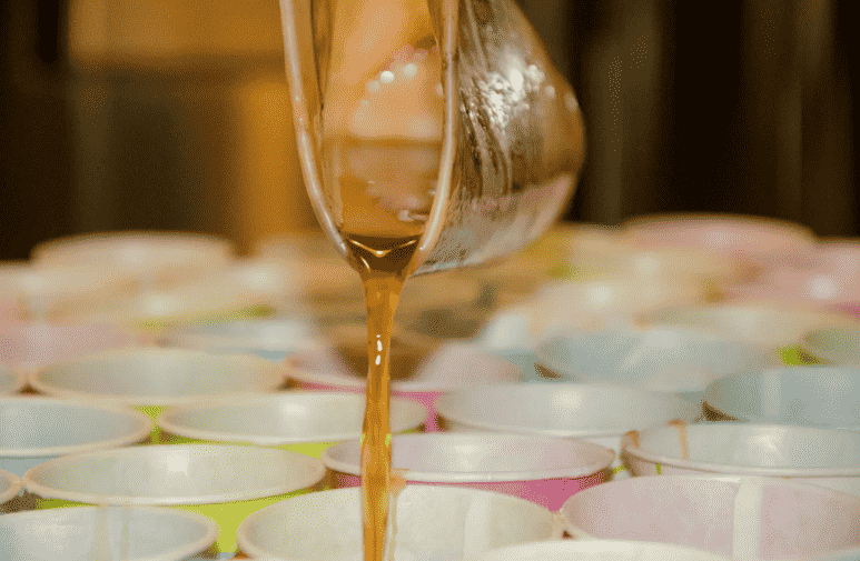 Dixie cups with wax being poured.
