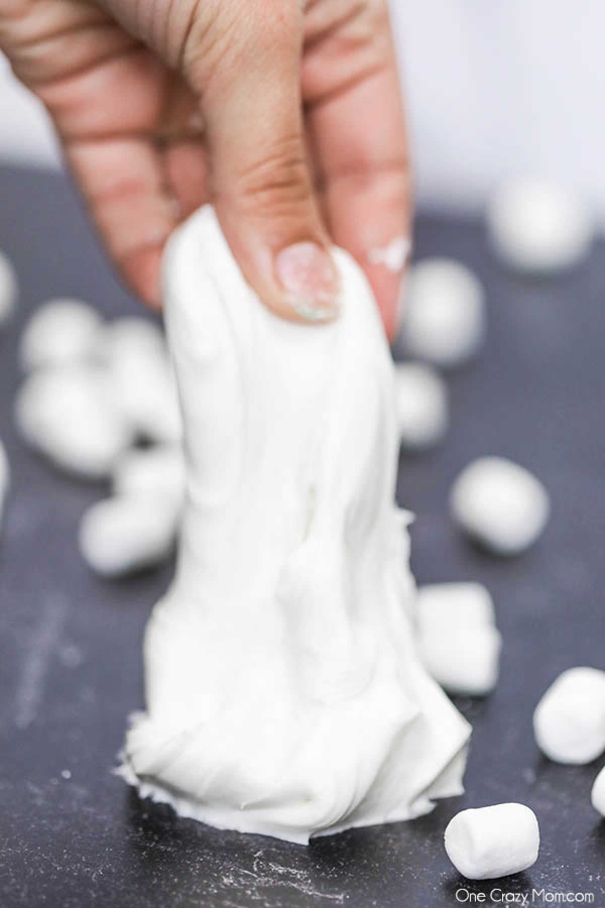 Marshmallow Slime is so fun to make and it is edible too! Gather the kids for this fun activity and learn how to make marshmallow slime. Marshmallow slime stretched in hands.