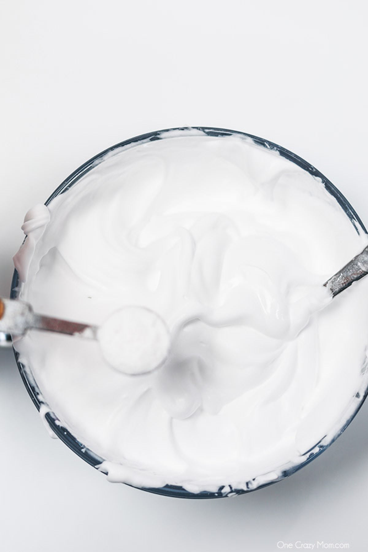 Snow Slime is so fun to make and only requires a few supplies. This is super easy and the kids will go crazy over this snow slime recipe. Ingredients being combined in a bowl.