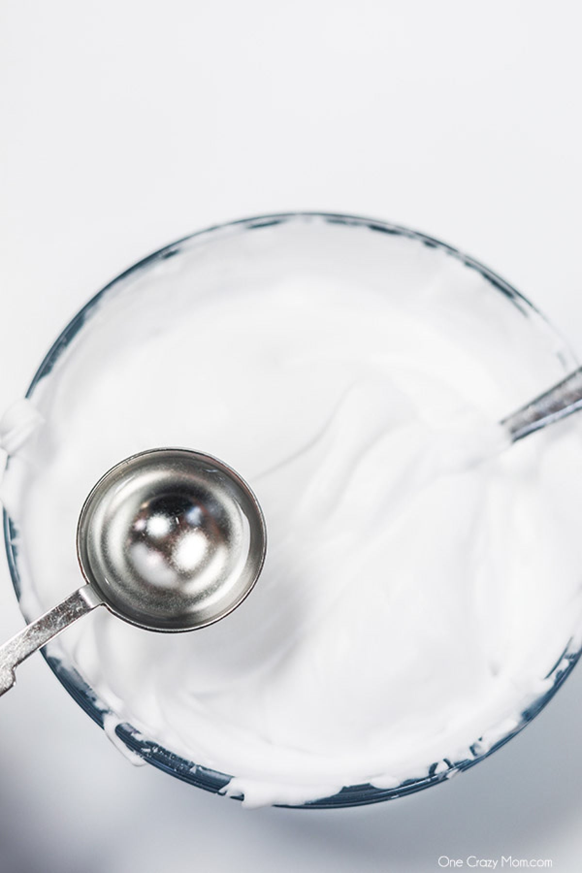 Snow Slime is so fun to make and only requires a few supplies. This is super easy and the kids will go crazy over this snow slime recipe. Contact solution being added to the mixture.