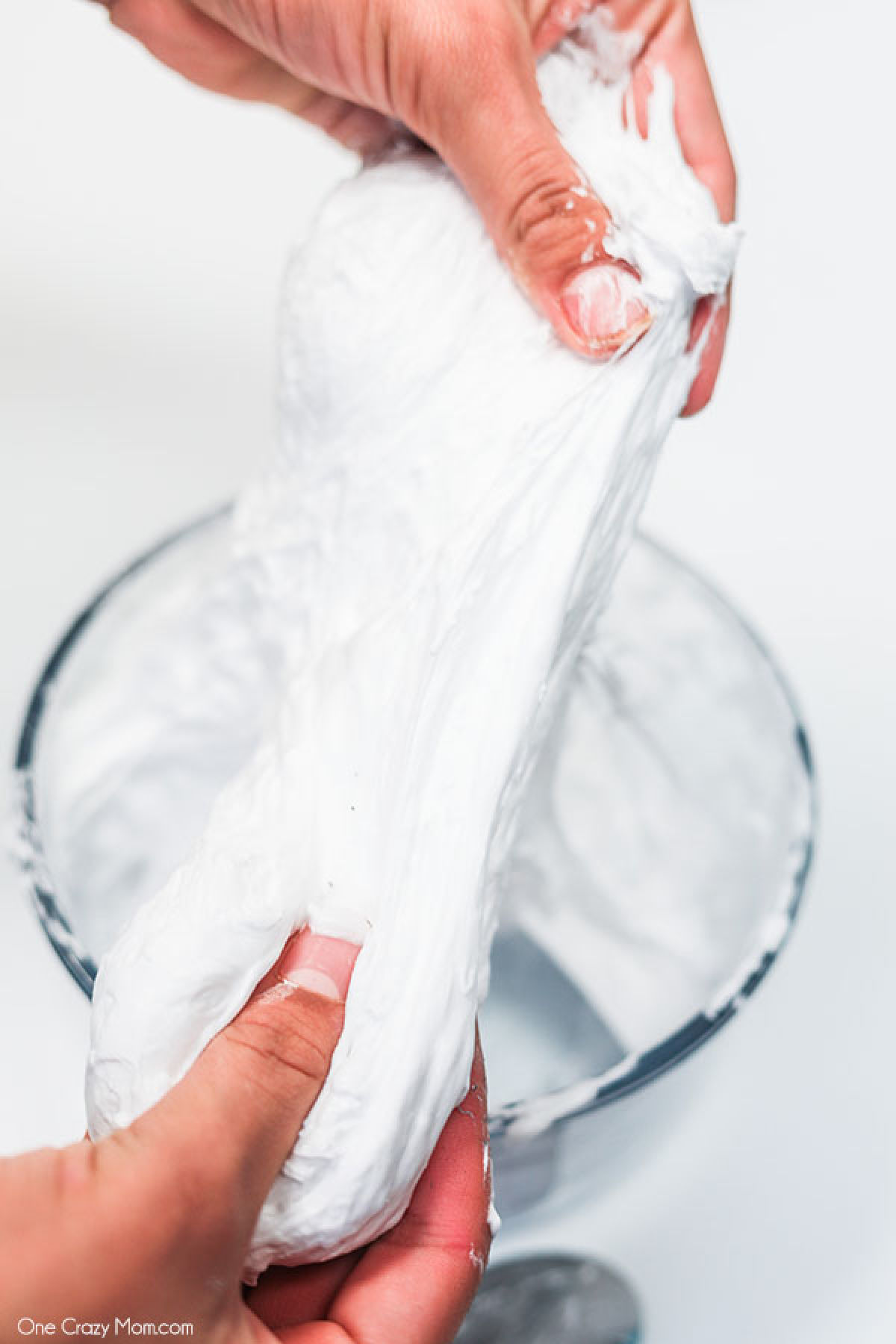 Snow Slime is so fun to make and only requires a few supplies. This is super easy and the kids will go crazy over this snow slime recipe. Snow Slime being stretched and pulled.
