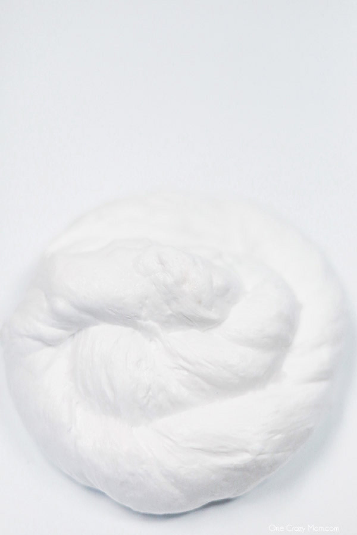 Snow Slime is so fun to make and only requires a few supplies. This is super easy and the kids will go crazy over this snow slime recipe. Pile of snow slime.