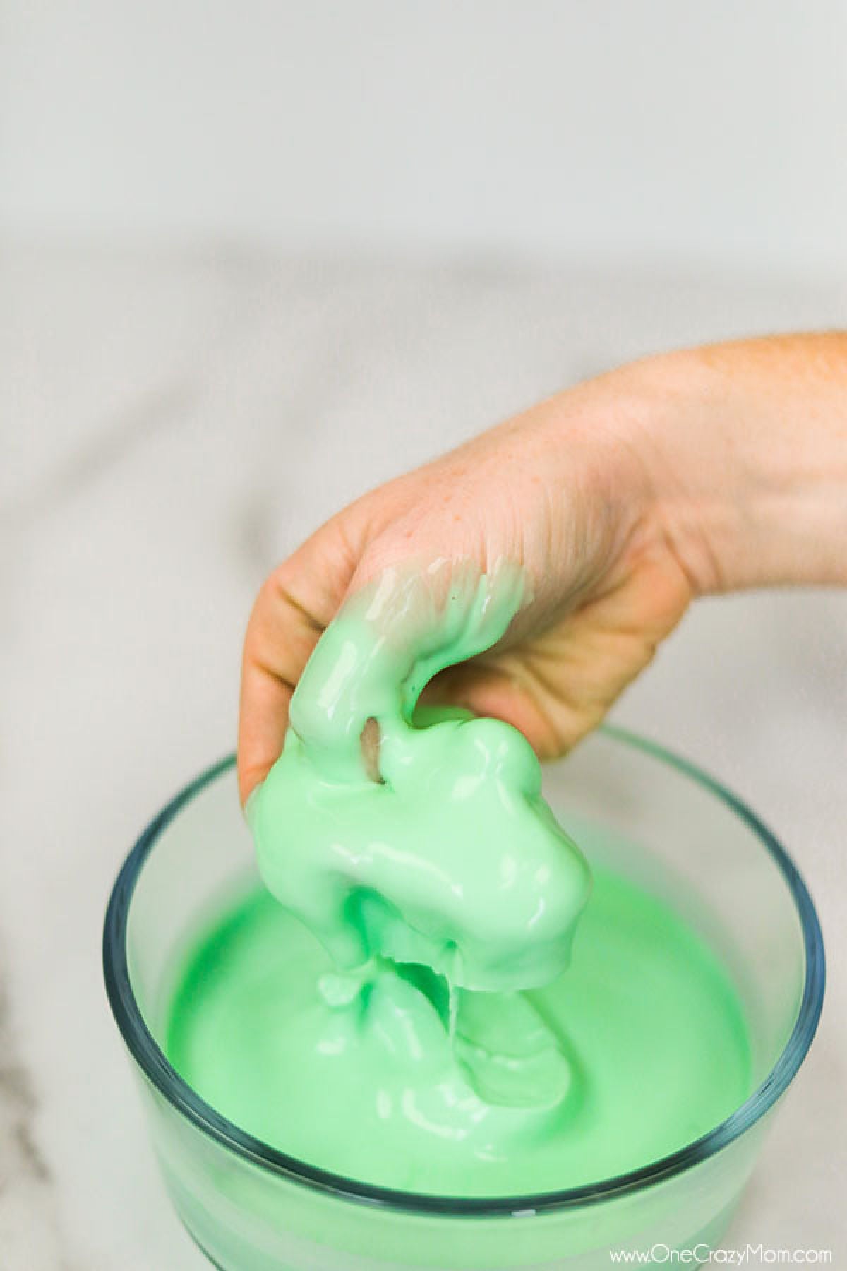 If your kids like to make slime, they will enjoy learning how to make oobleck. You only need 2 ingredients and this DIY doubles as a science experiment. Oobleck in bowl with hand in it.