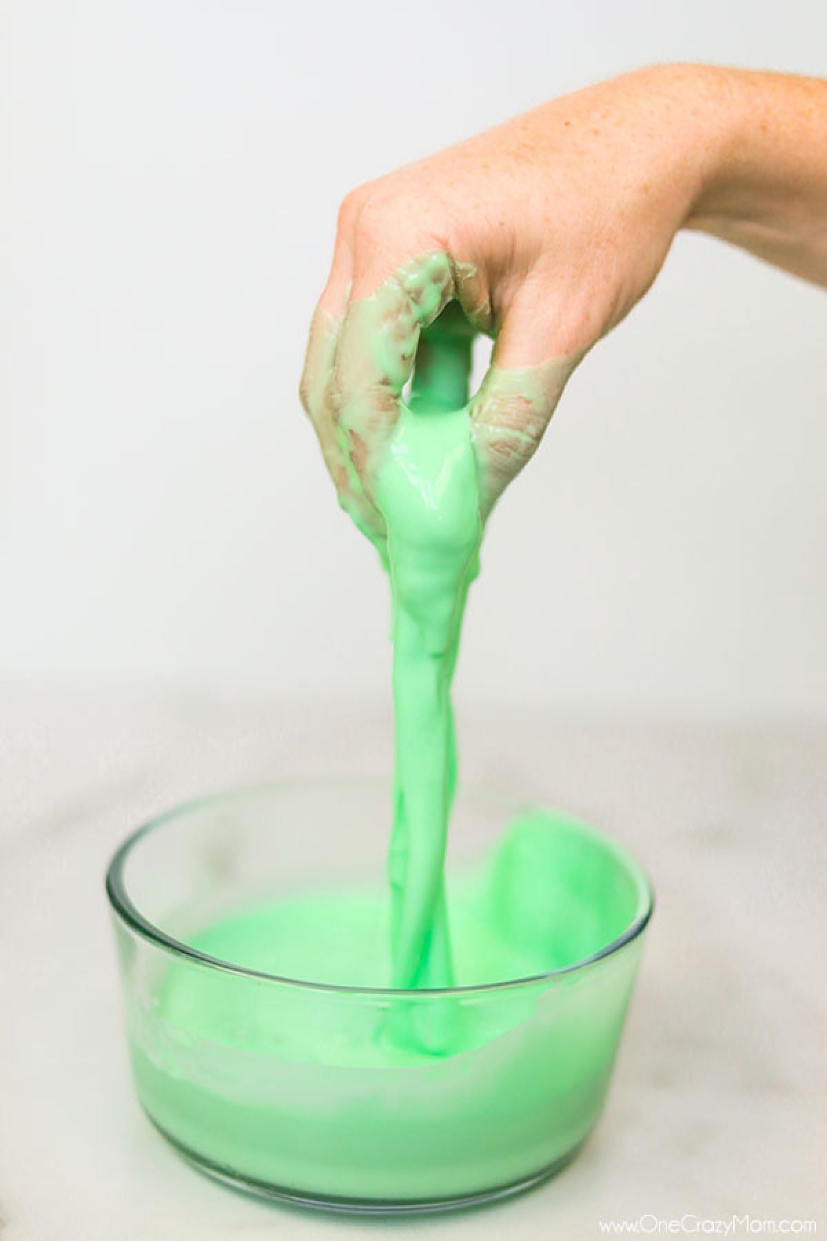 If your kids like to make slime, they will enjoy learning how to make oobleck. You only need 2 ingredients and this DIY doubles as a science experiment. Oobleck in bowl with hand in it.