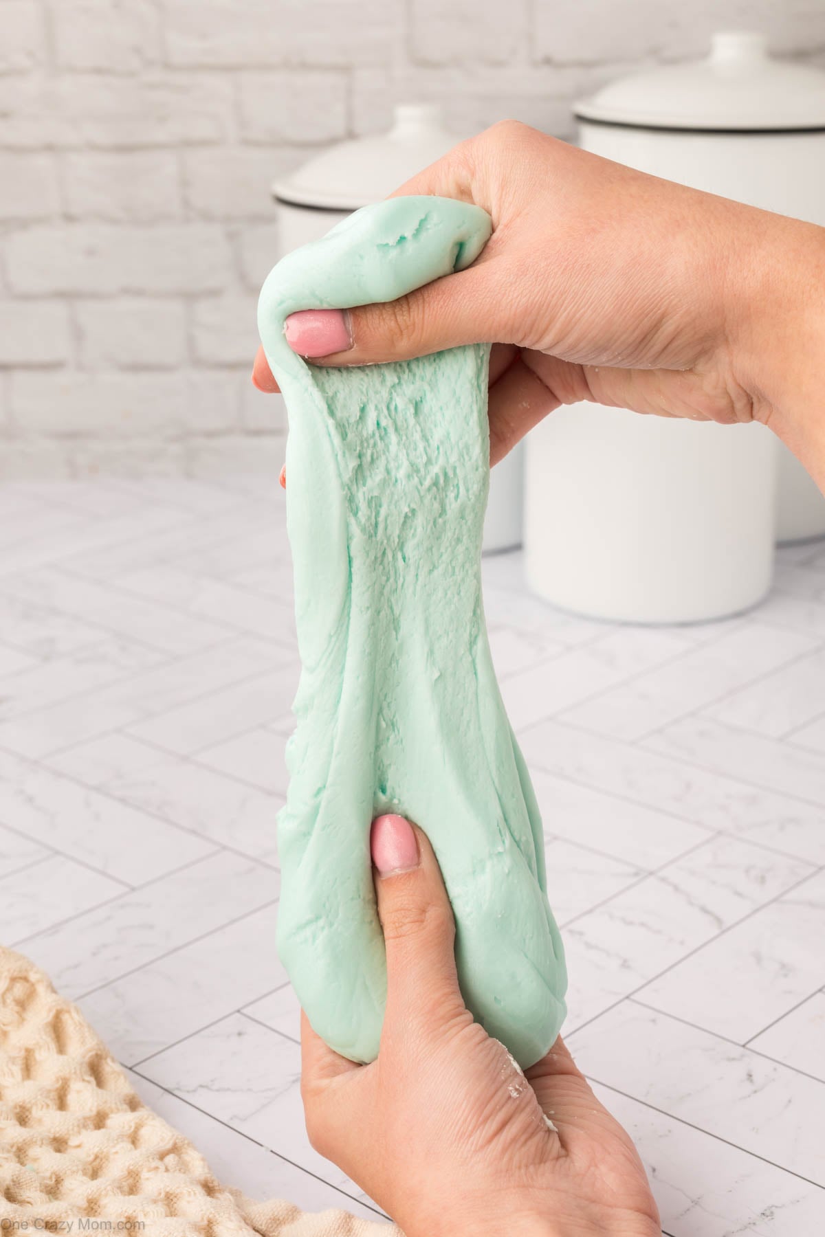 Slime in hands being stretched.