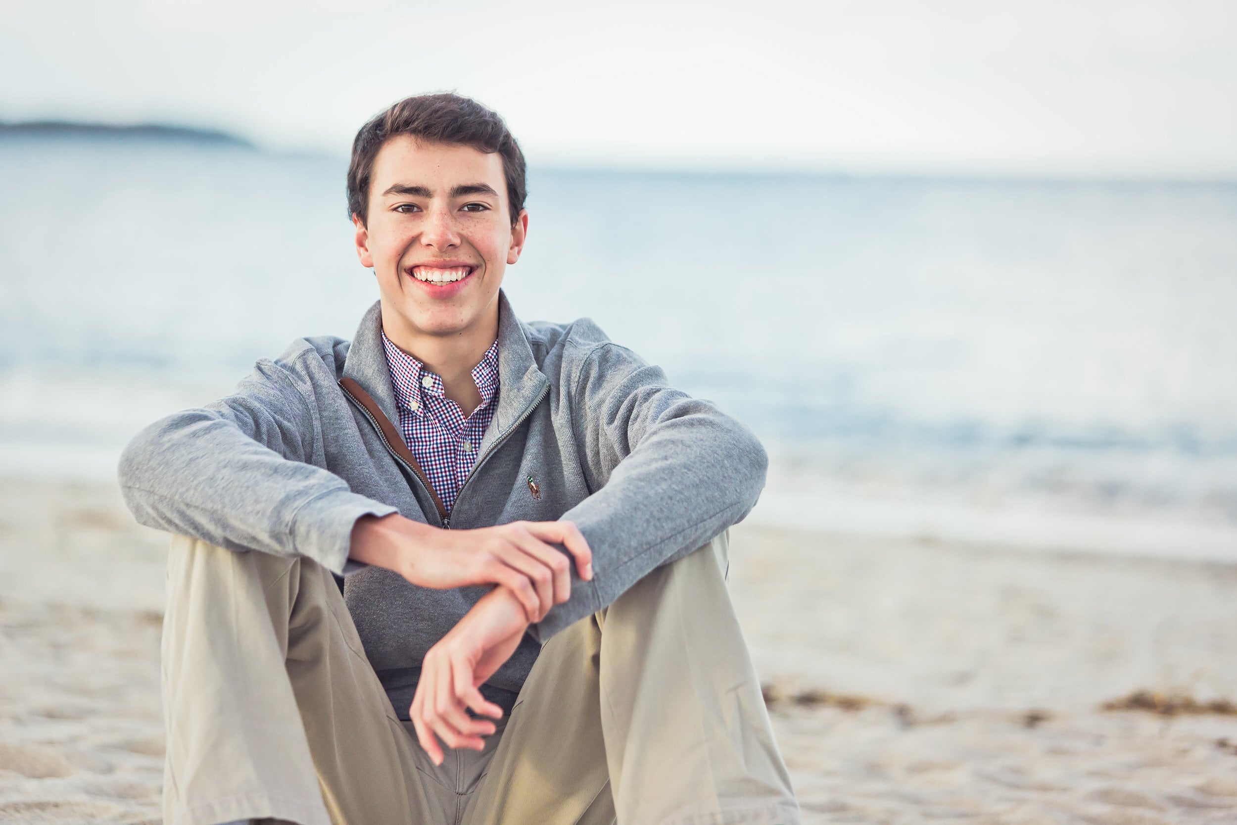 Boy sitting on beach.