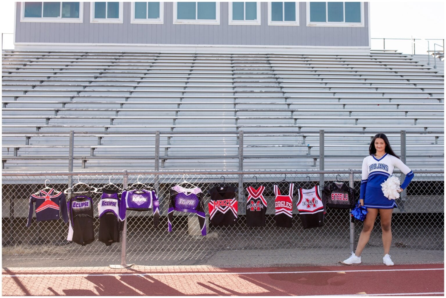 Cheerleader standing beside uniforms.